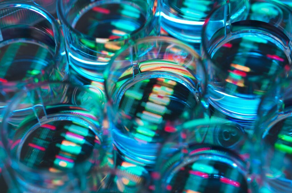 A human sample in a multi well plate ready for genetic analysis with a DNA sequence in the background