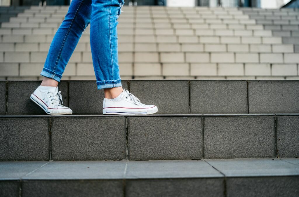 Young woman with backpack going down a staircase.