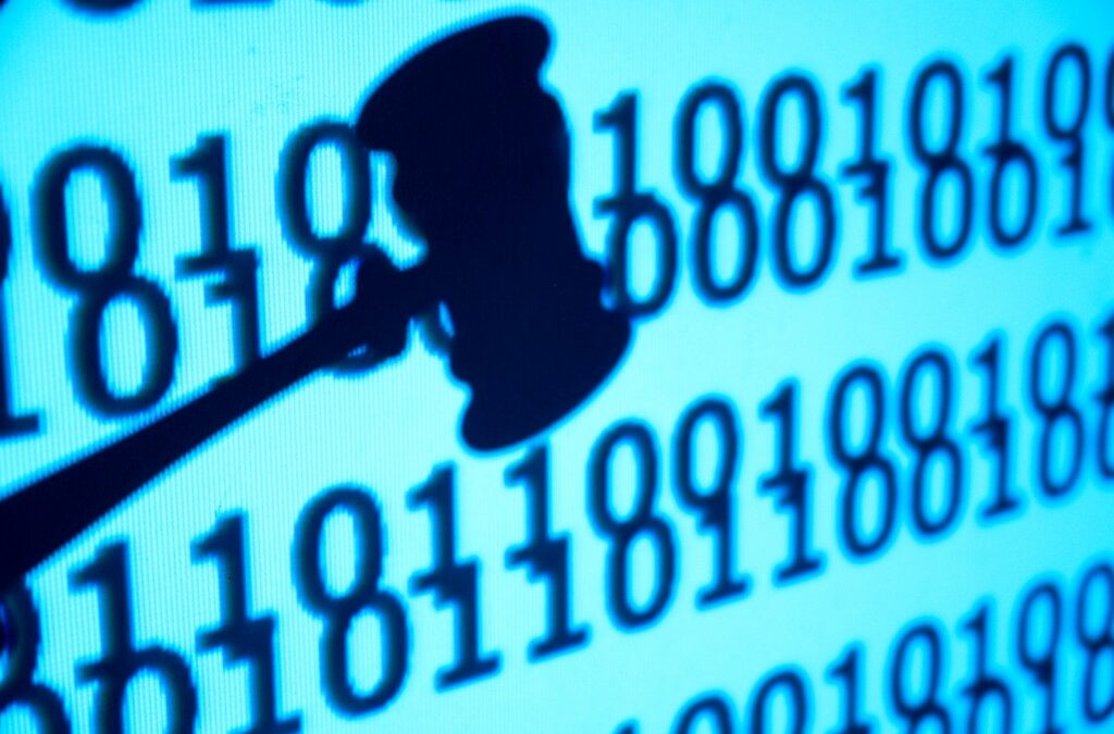 An image of a close up gavel in front of code, concept of justice and lawsuit