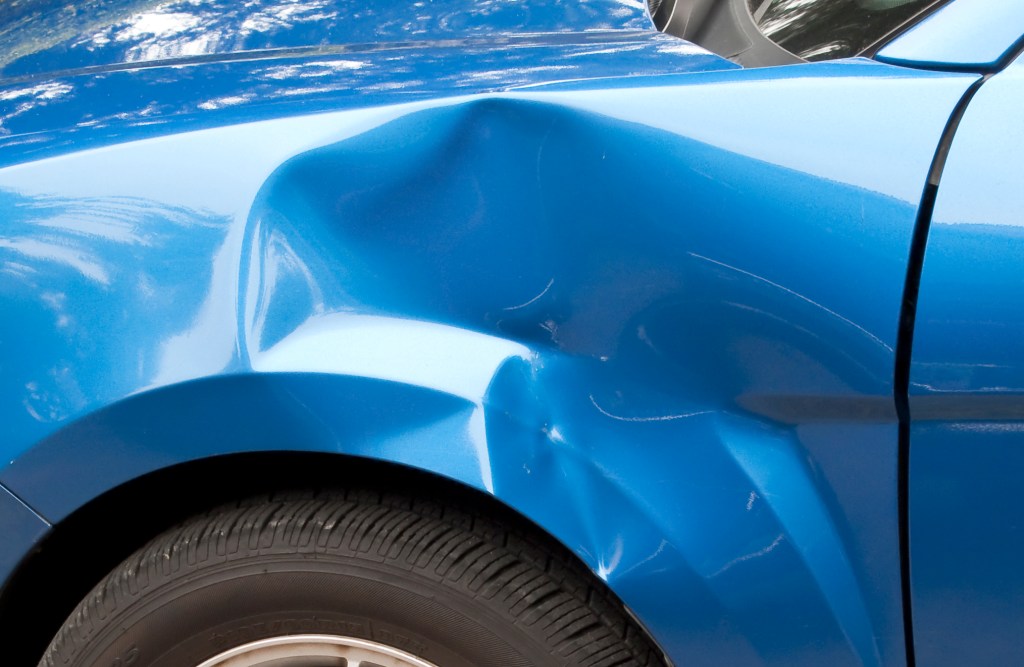 Auto accident leaving a huge dent in the left front quarter panel.