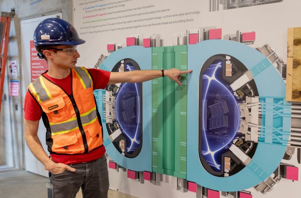 Alex Creely, director of Tokamak operations at Commonwealth Fusion Systems, points to a reactor schematic.