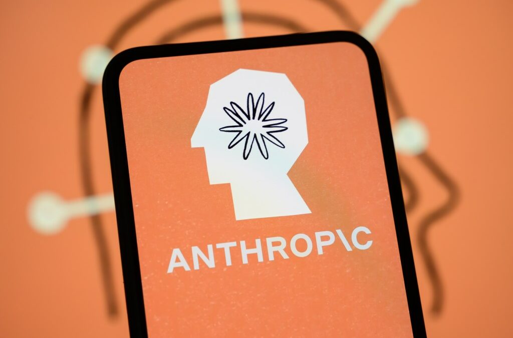 The Anthropic logo is displayed on the screen of a smartphone with the company's branding in the background.