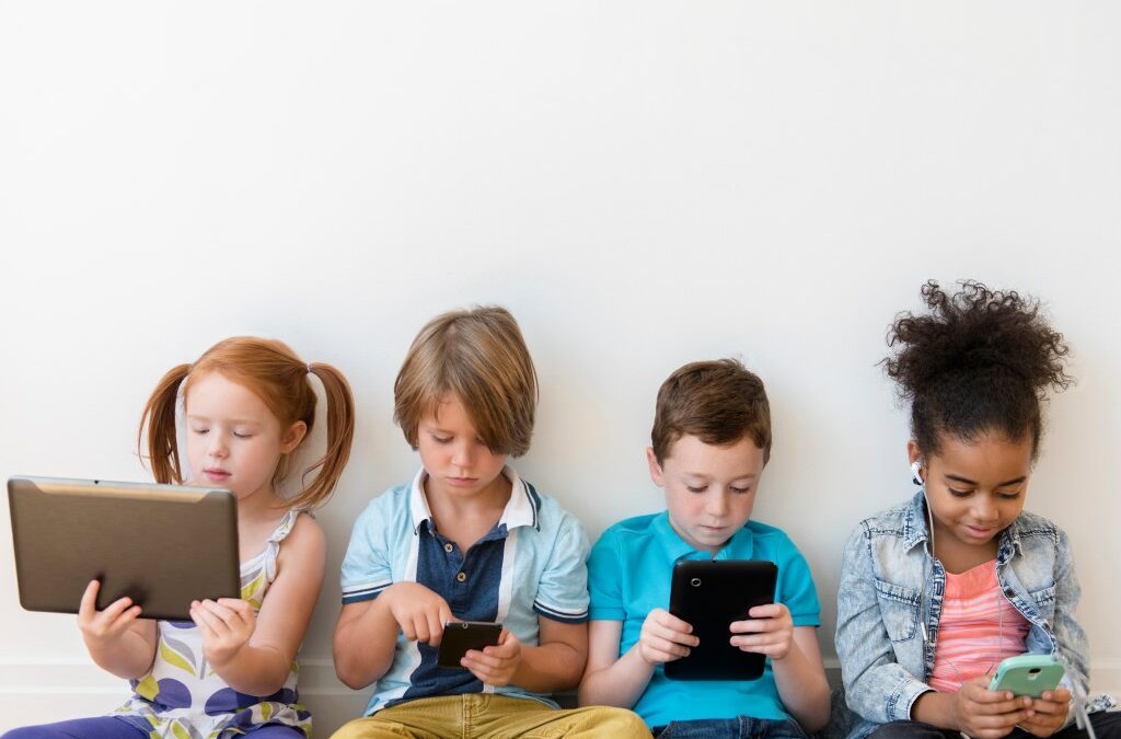 Image of four children using tablets and smartphones.