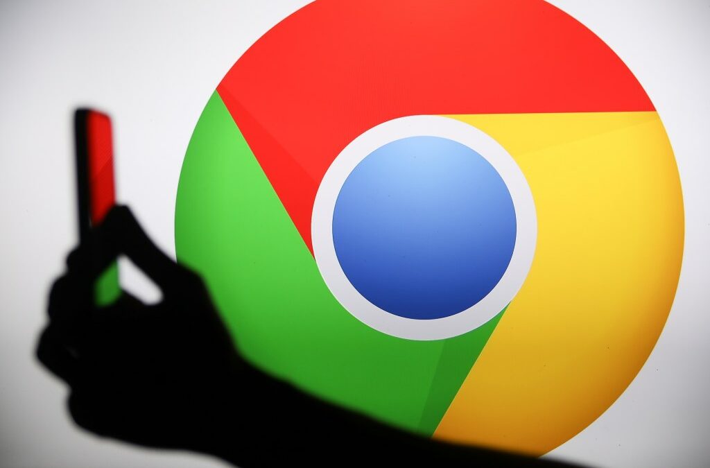 The Chrome logo displays on a screen with a person holding a phone.