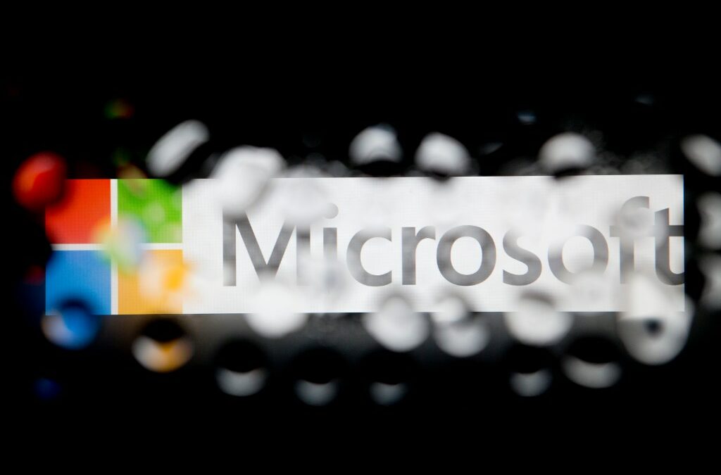 The Microsoft Corp. logo is seen through water droplets.