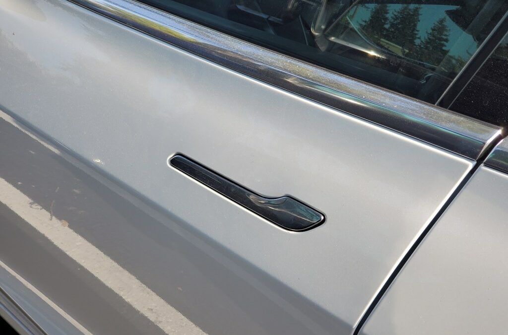 Close-up of flush-mounted, retracting door handle on Tesla automobile.