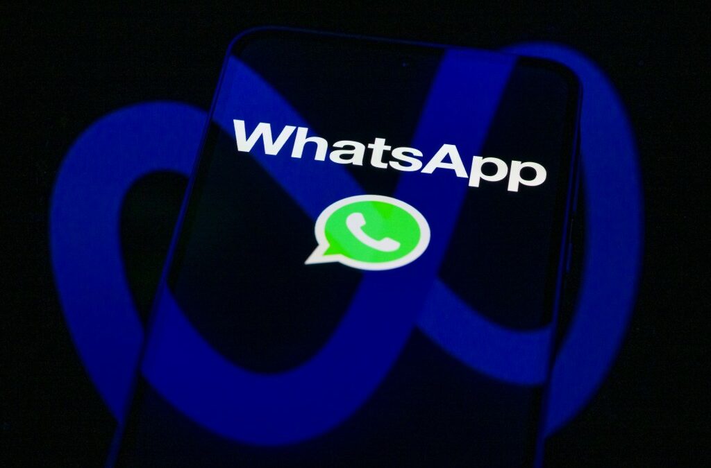 The WhatsApp logo is displayed on a mobile phone screen in this photo illustration.